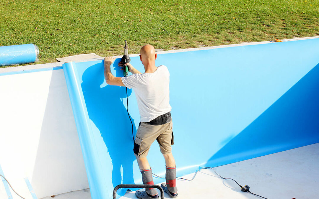 A worker welds plastic cover for water pool